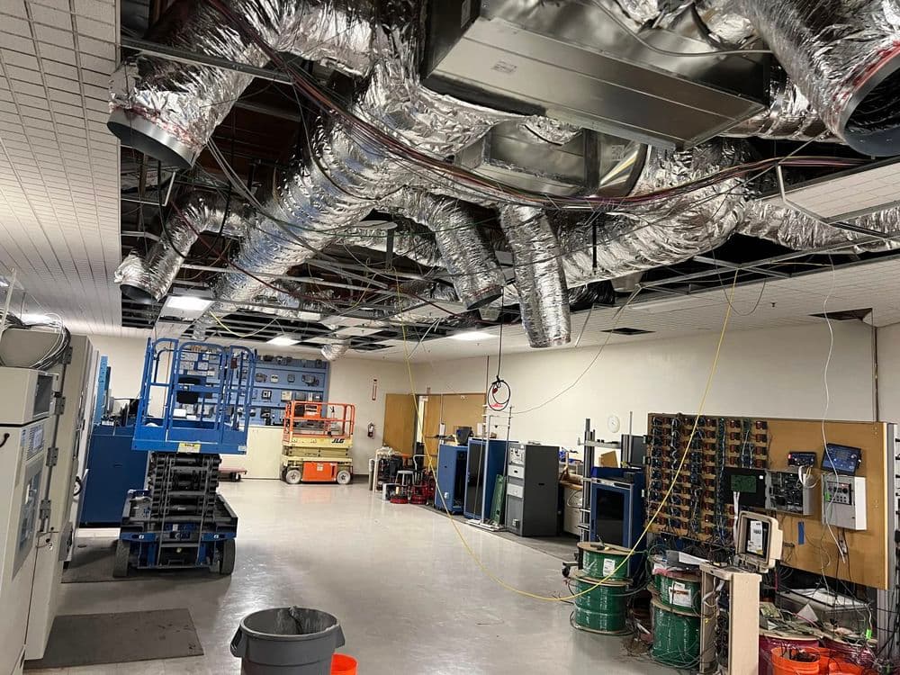 Industrial workspace featuring exposed ductwork, machinery, and organized equipment.